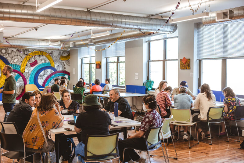 An undated image from an UpStart retreat, people seated in a large office room. Jill Tiongco Photography