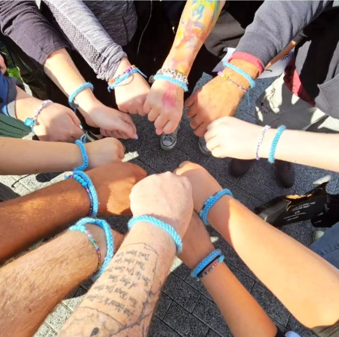 Hands wearing a light blue bracelet